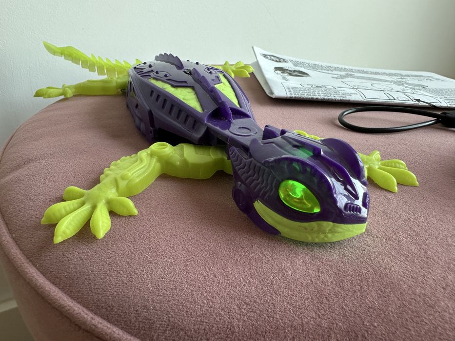 Șopârlă Gecko cățărătoare pe perete cu telecomandă