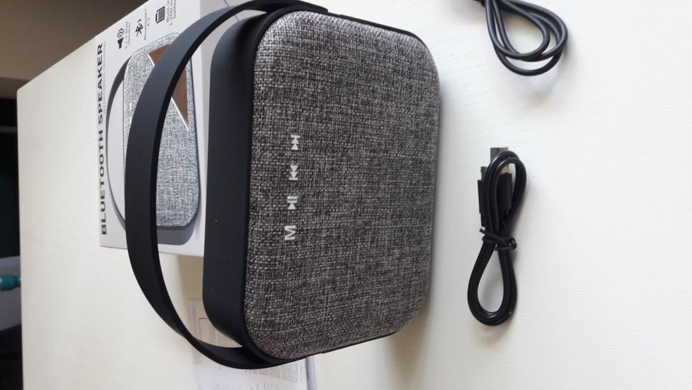 Блутут колонка говорител с текстилна обвивка и гумирана дръжка.