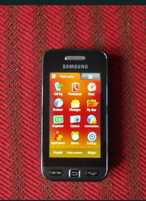 Telefon cu touchscreen și cameră, foarte mic, robust, ocupă puțin spațiu și foarte practic.