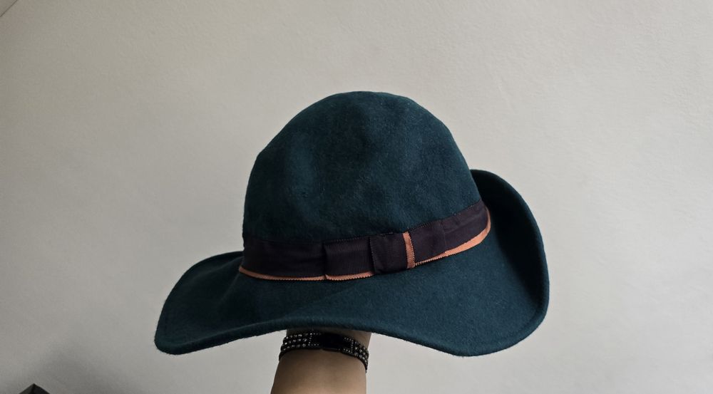 Зимна вълнена тъмно зелена дамска шапка.