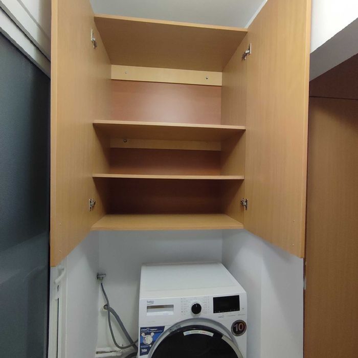 Dulap suspendat deasupra mașini de spălat.