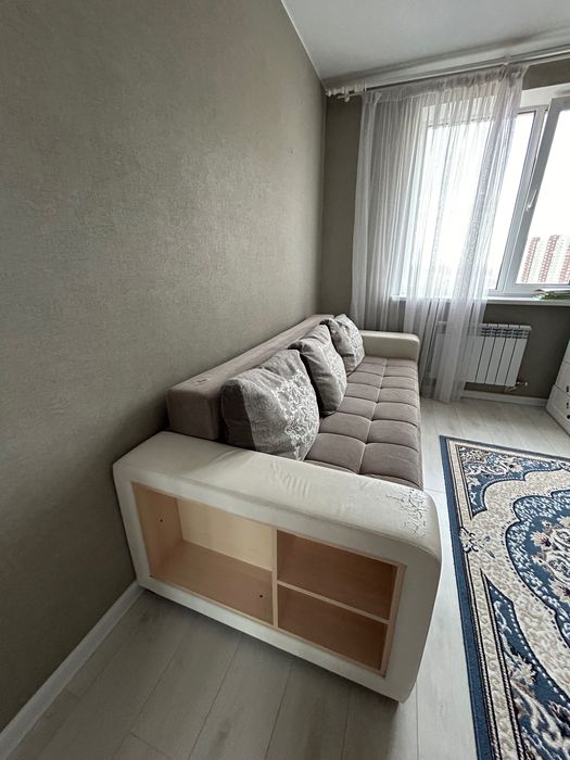 Диван серого цвета с белыми кожаными подлокотниками