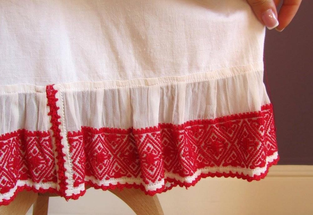 ie și poale cusute pe marchizet cu fir de bumbac de culoare roșie.