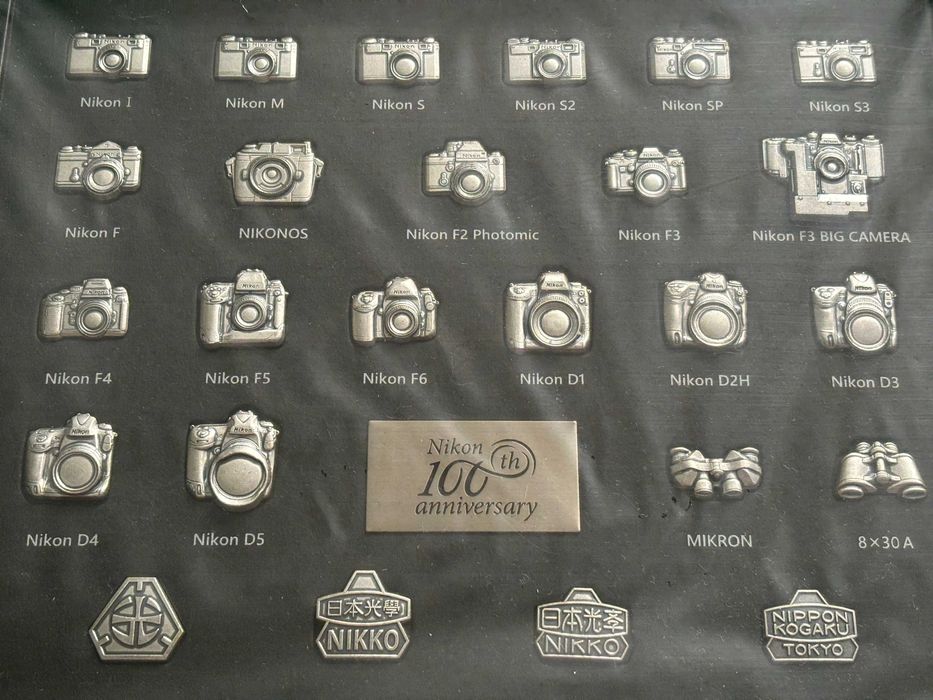 Colectie aniversara de insigne (pin) 100 ani aparate foto Nikon