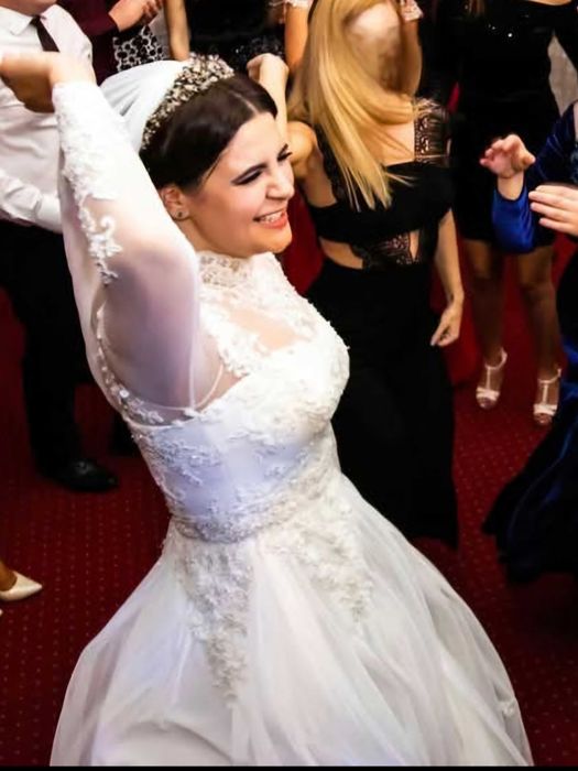 Rochie de mireasă brodată manual, stil palat, cu gât și mâneci lungi.