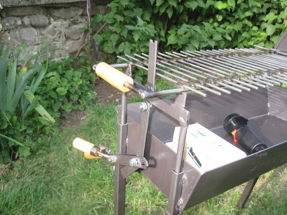 Барбекю на дървени въглища с въртящи се шишове и скара.