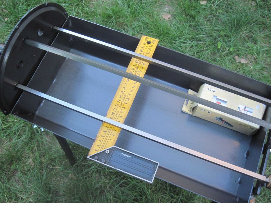 Барбекю на дървени въглища с въртящи се шишове и скара.