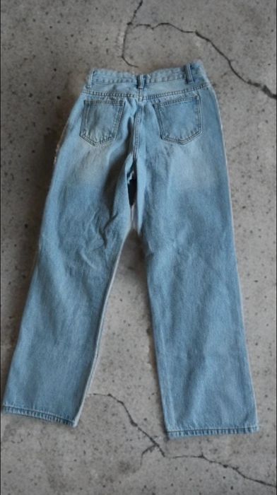 Blugi damă tip straight fit, talie înaltă, denim, preț negociabil albastru deschis. Model modern cu rupturi decorative în zona genunchilor.