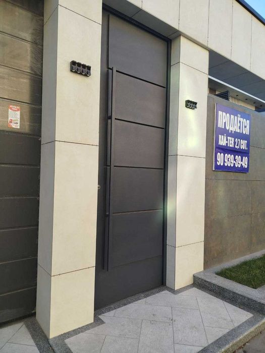 Входные двери в едином стиле с секционными воротами.