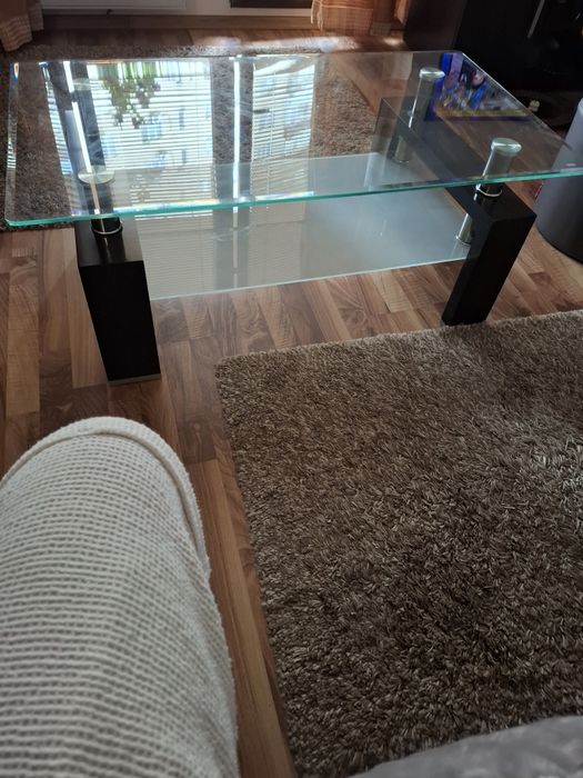 Măsuță de cafea modernă, realizată dintr-o combinație de sticlă, metal și lemn .