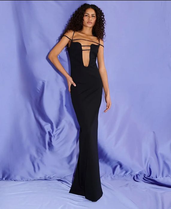 Елегантна черна рокля с изрязан акцент и фини презрамки.