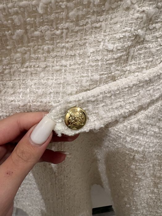 Бяла къса пола с висока талия и разкроен силует.