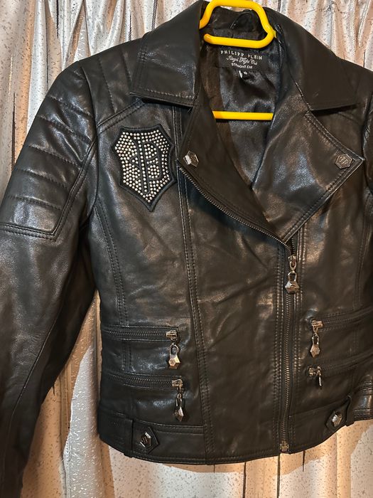 Vand geaca de dama neagra Philipp Plein, cu desing elegant, croiala biker, fermoar asimetric. Geaca este intr-o stare foarte buna.