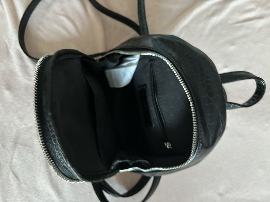 Черна, кажена раница с регулируеми презрамки.