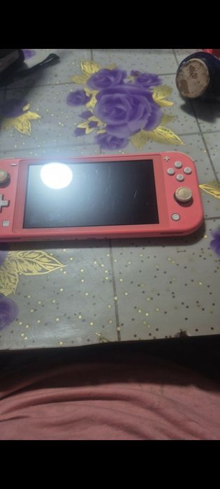 "De vânzare Nintendo Switch Lite, coral. Vine cu jocul Pokémon Sword sau  Pokémon Shield. Atenție: nu include încărcător.
