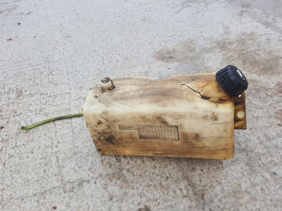 Rezervor de combustibil pentru tractor de gazon sau mașină. Acesta este construit din plastic și prezintă semne de uzură