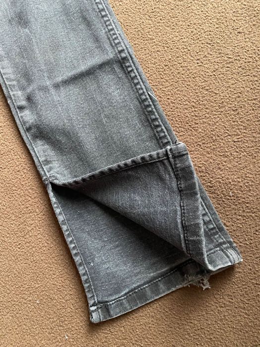 Черни тесни дънки с цепка в долната част на крачолите