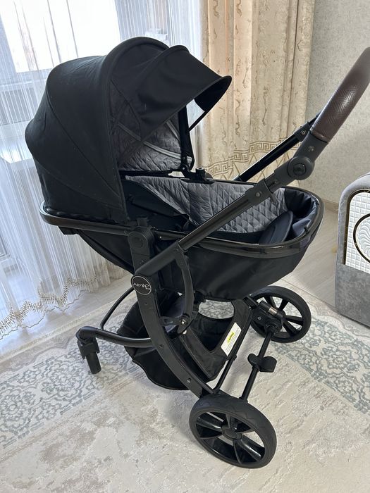 Продаётся современная детская коляска в чёрном цвете.