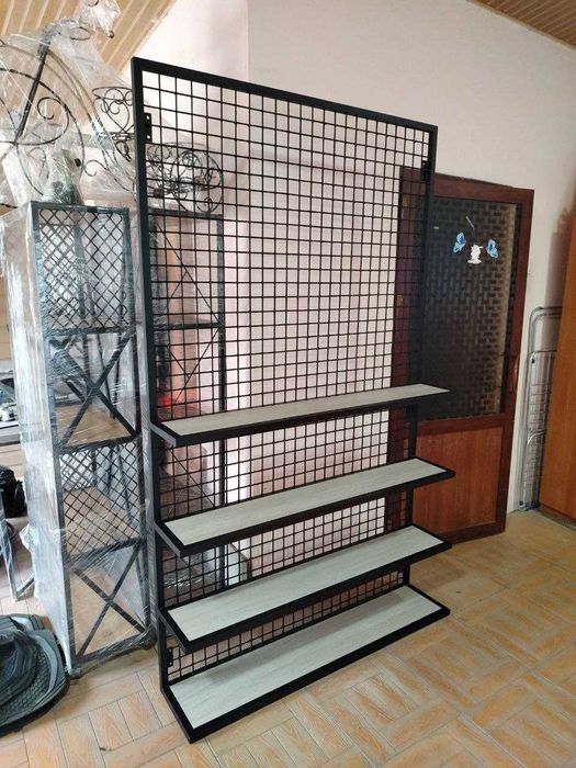 Стеллаж с металлической сеткой и полками крепится к стене.