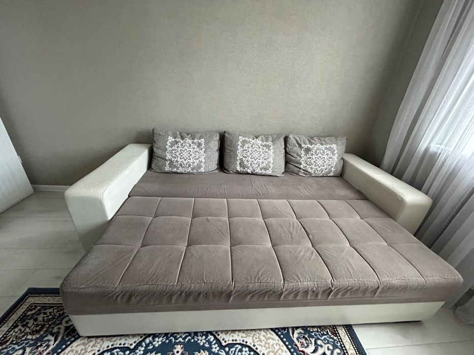 Диван серого цвета с белыми кожаными подлокотниками