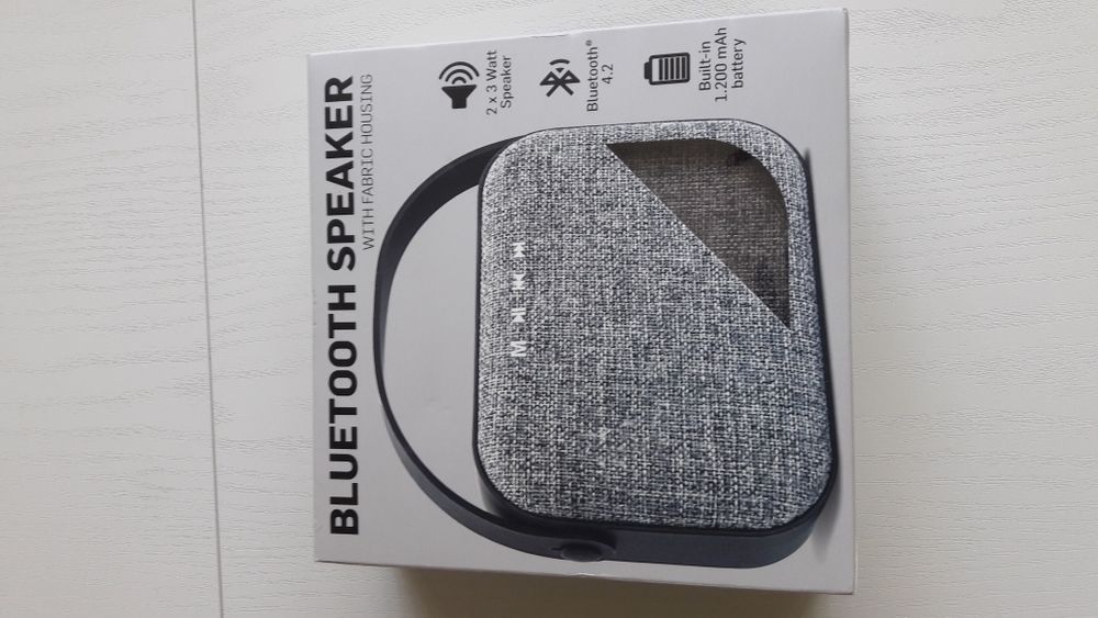 Блутут колонка говорител с текстилна обвивка и гумирана дръжка.