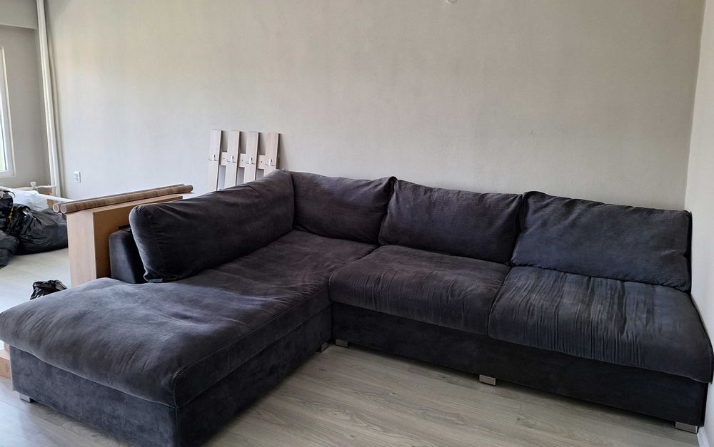 Дивана е в сив цвят, подходящ е за голям хол.