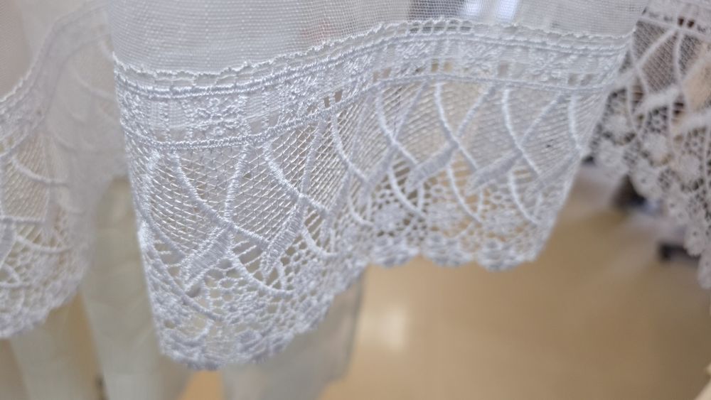o perdea albă gata confecționată, în stil clasic/romantic, potrivită de regulă pentru bucătării, balcoane sau ferestre de dimensiuni medii și mici.