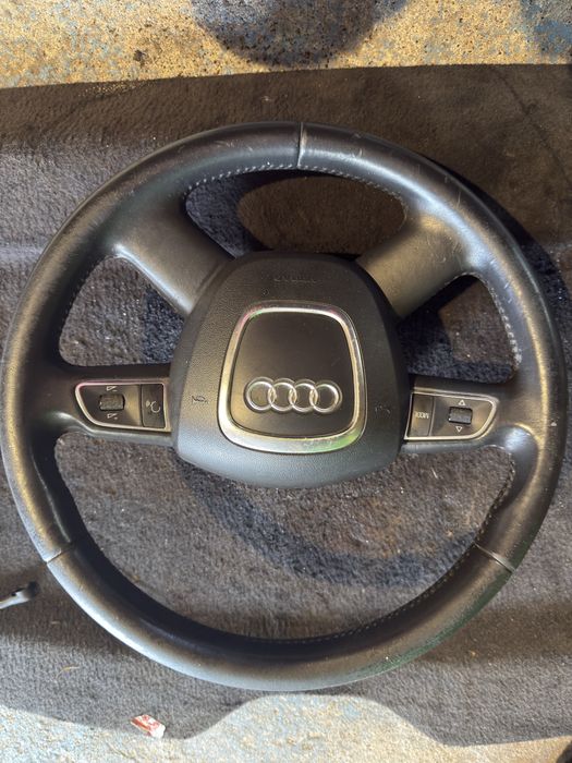 volan din piele cu 4 spițe și comenzi multifuncționale, specific pentru modele Audi (precum Audi A3 8P, A4 B8, A5, Q3, Q5 sau Q7)
