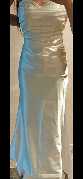 Сватбена сатенена рокля с дълъг шлейф и подходящи ръкавици към нея.