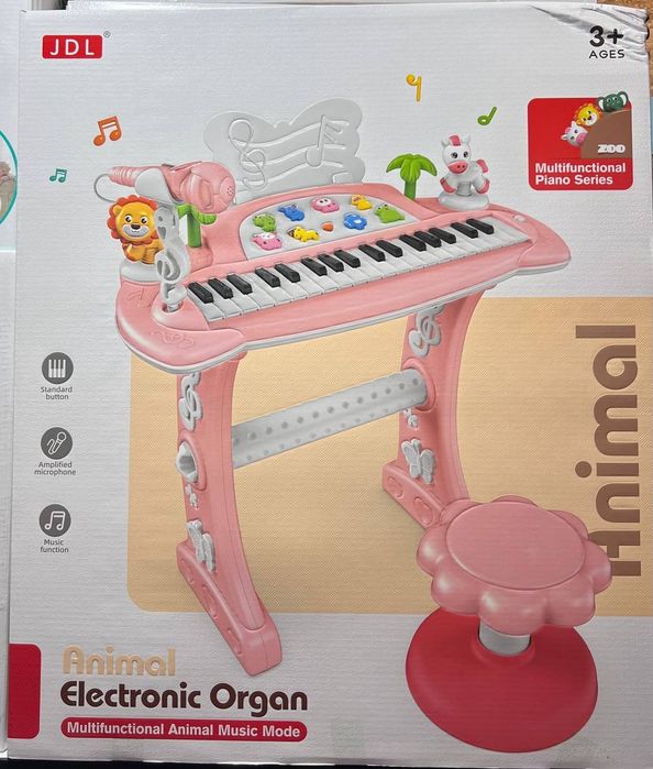 детское электронное пианино розового цвета с микрофоном и стульчиком.