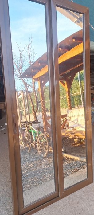 Ușă culisantă dublă, de culoare maro cu oglinda pe o parte