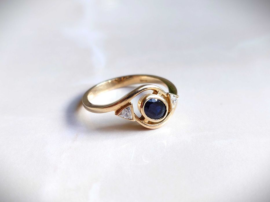 Inel Aur de 18 k cu 2 diamante Trillion Cut si un safir albastru.