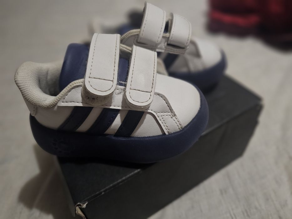 Това са детски бебешки маратонки Adidas  в бяло и тъмносин цвят.