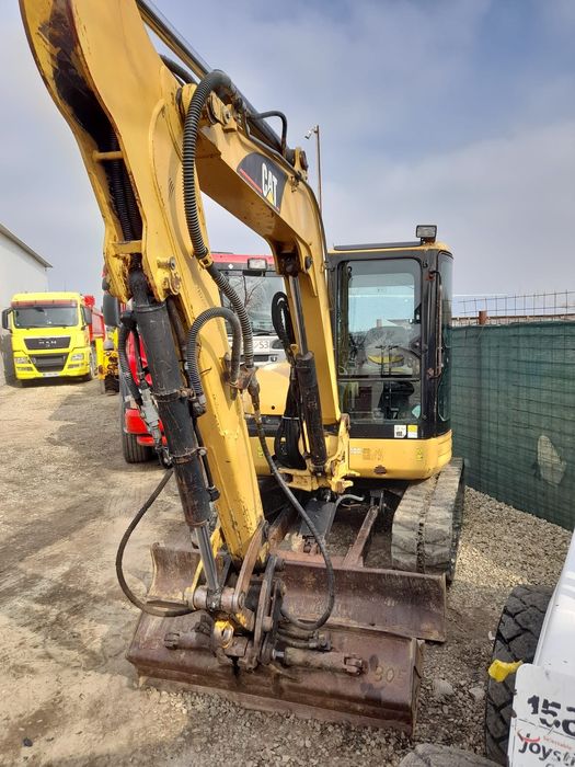 Miniexcavator Caterpillar 5,5t cu 4 cupe  din care cea de taluz rotat
