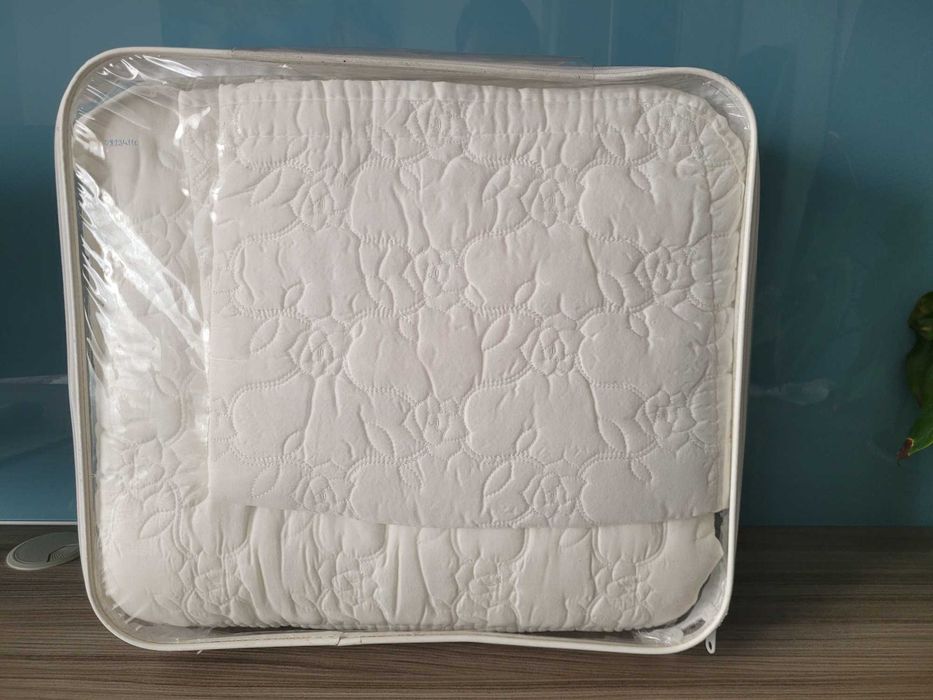 set de cuvertură de pat albă, matlasată, disponibil de obicei în seturi de 3 piese (o cuvertură și două fețe de pernă).