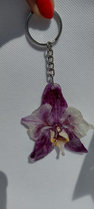 Ключодържател или аксесоар за чанта с естествен цвят на орхидея.