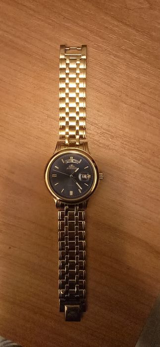 Acesta este un ceas Astron cuarț în tonuri de aur, cu un cadran albast