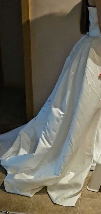 Сватбена сатенена рокля с дълъг шлейф и подходящи ръкавици към нея.