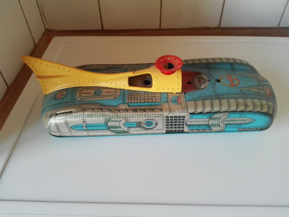 Две стари картини графика , пластмасови животни и ламаринен луноход .