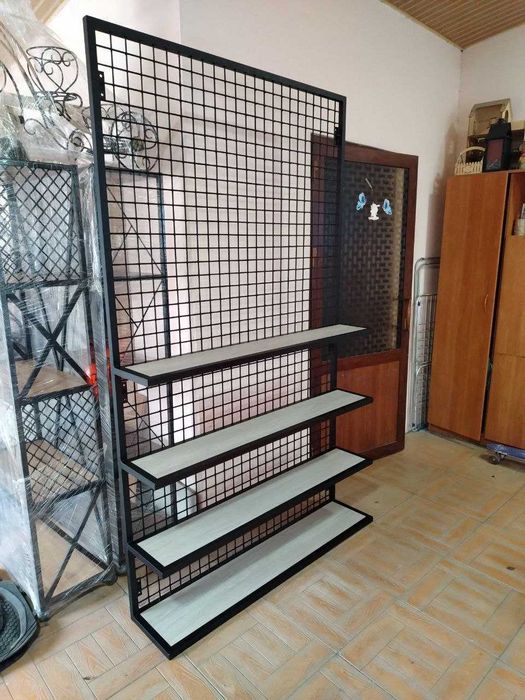 Стеллаж с металлической сеткой и полками крепится к стене.