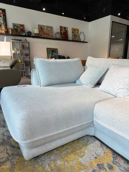 Canapea extensibila, in forma de L, cu sezlong pe partea dreapta, pat 160x200 cm, tapiterie crem deschis, brate cu detaliu de cusatura.