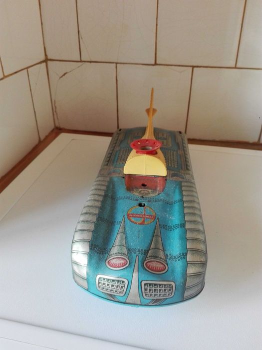 Две стари картини графика , пластмасови животни и ламаринен луноход .