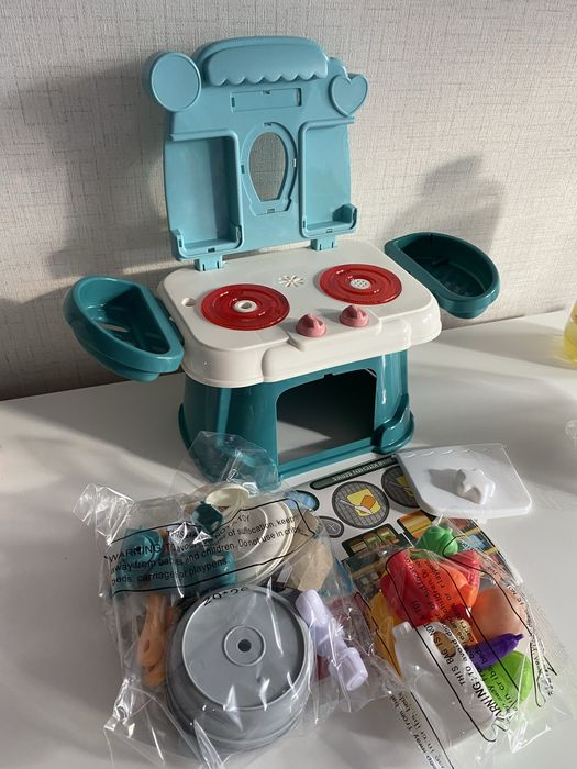 Малка зелена кухня със светещи котлони, пара и мивка с вода