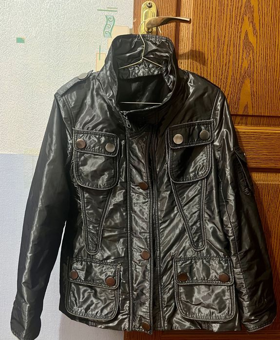 Куртка-сафари с четырьмя карманами и металлическими пуговицами.