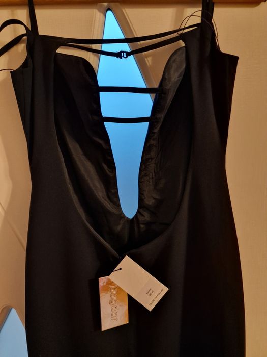 Елегантна черна рокля с изрязан акцент и фини презрамки.