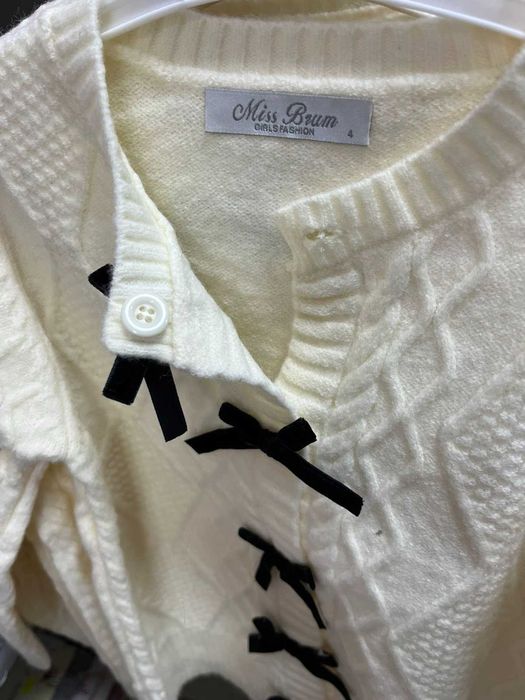 Детска плетена жилетка с червени кадифени панделки