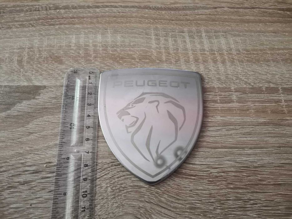 бяла метална емблема Peugeot с новото лого