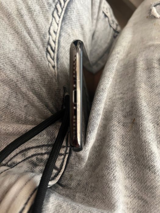 iPhone X cu spatele spart și cu mizerie în portul de încărcare