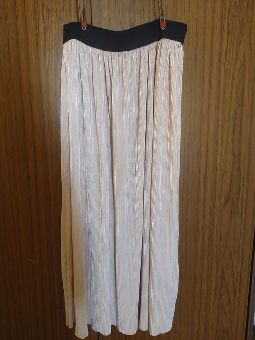 Плисирана пола в прасковен цвят с лек отблясък.