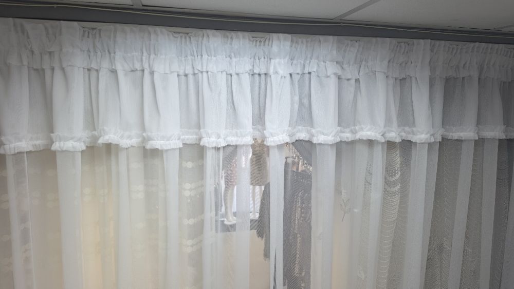 o perdea albă gata confecționată, în stil clasic/romantic, potrivită de regulă pentru bucătării, balcoane sau ferestre de dimensiuni medii și mici.